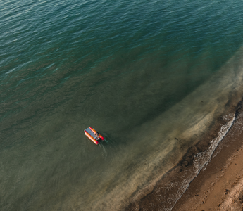 an aerial view of a small boat floating in the ocean