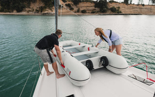 A couple launching their True Kit Inflatable boat from the yacht