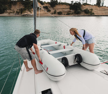 A couple launching their True Kit Inflatable boat from the yacht