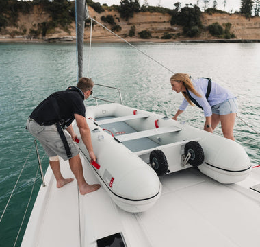 A couple launching their True Kit Inflatable boat from the yacht