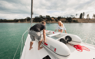 man and woman setting up sailboat
