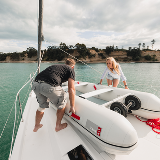 man and woman setting up sailboat